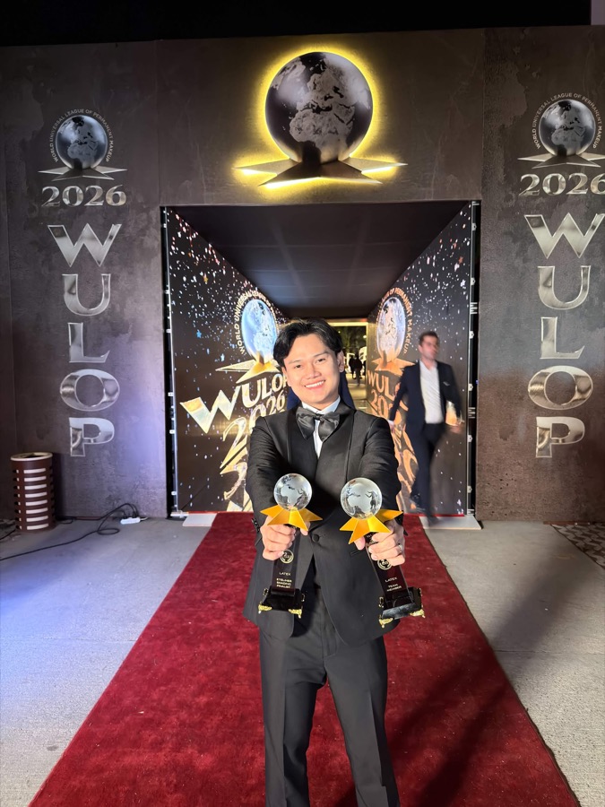 อาจารย์ทีน ถือถ้วยรางวัล 2 ใบ บนพรมแดงงาน WULOP 2026